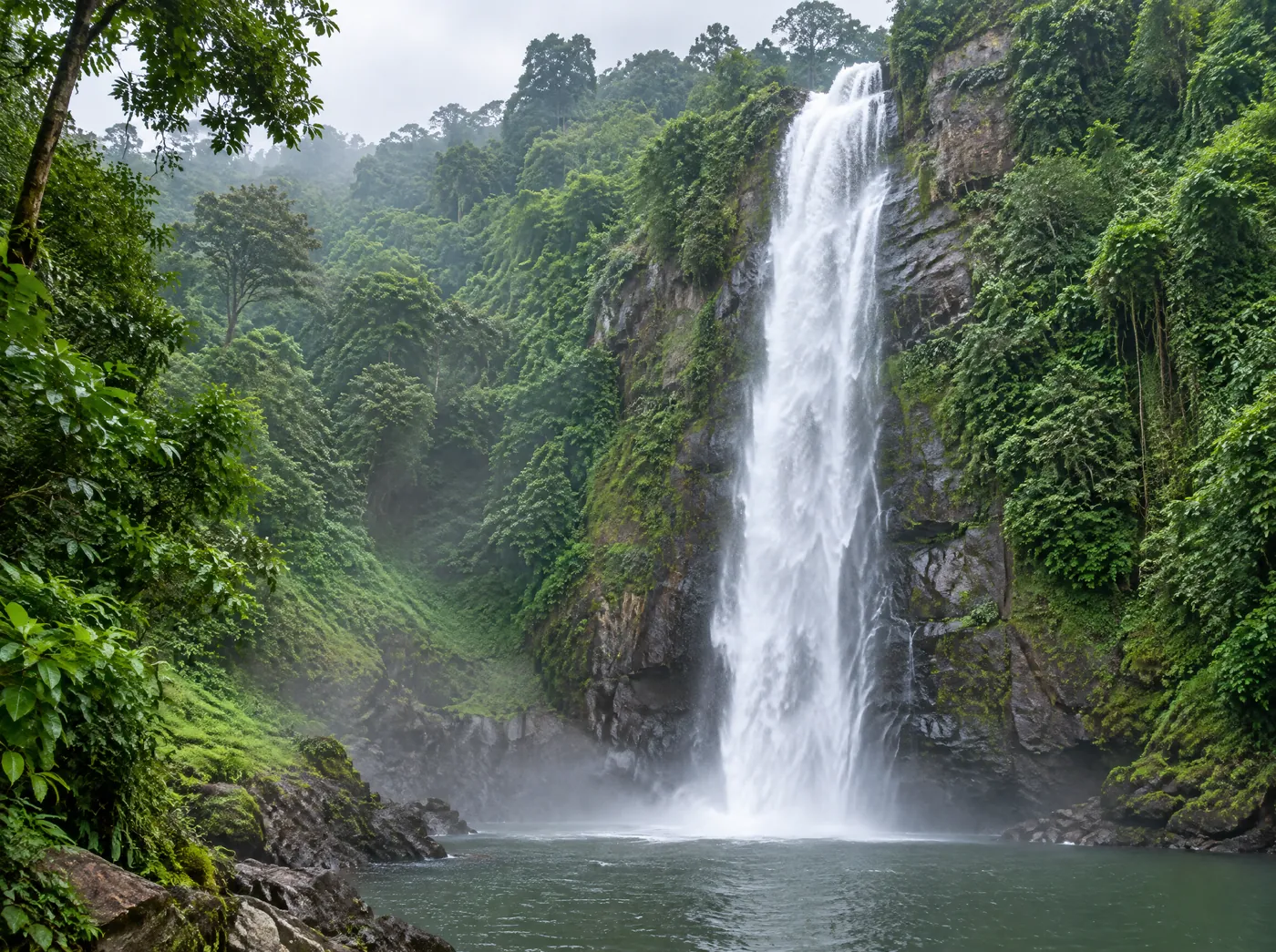 Wli Waterfalls dropping into a pool surrounded by forest